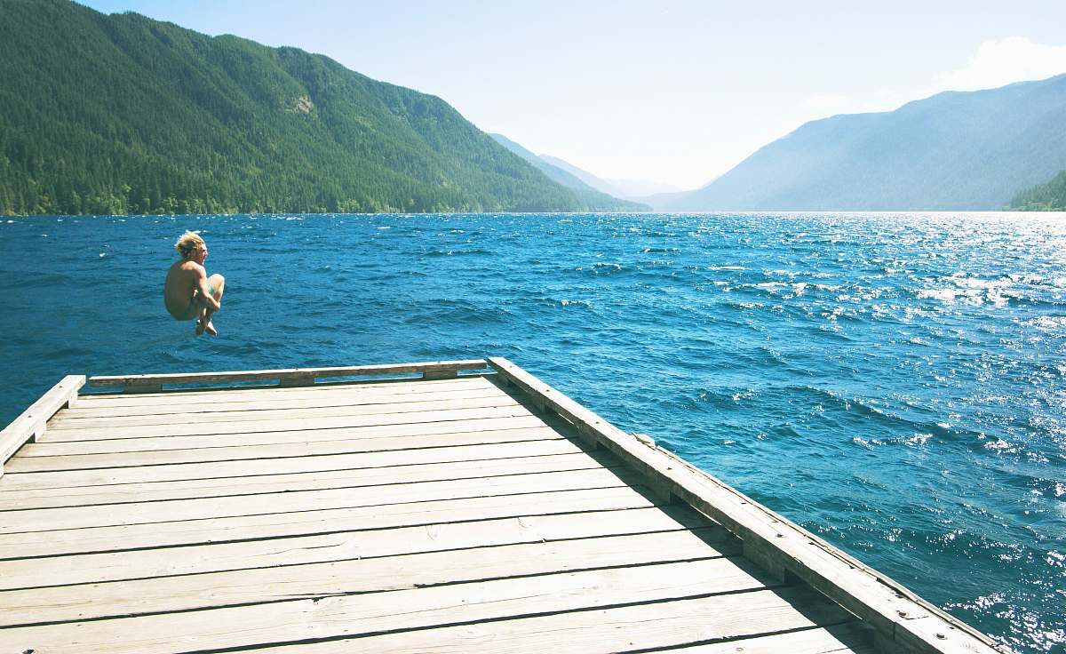 lake crescent topless person jumping towards water from white wooden dock dock